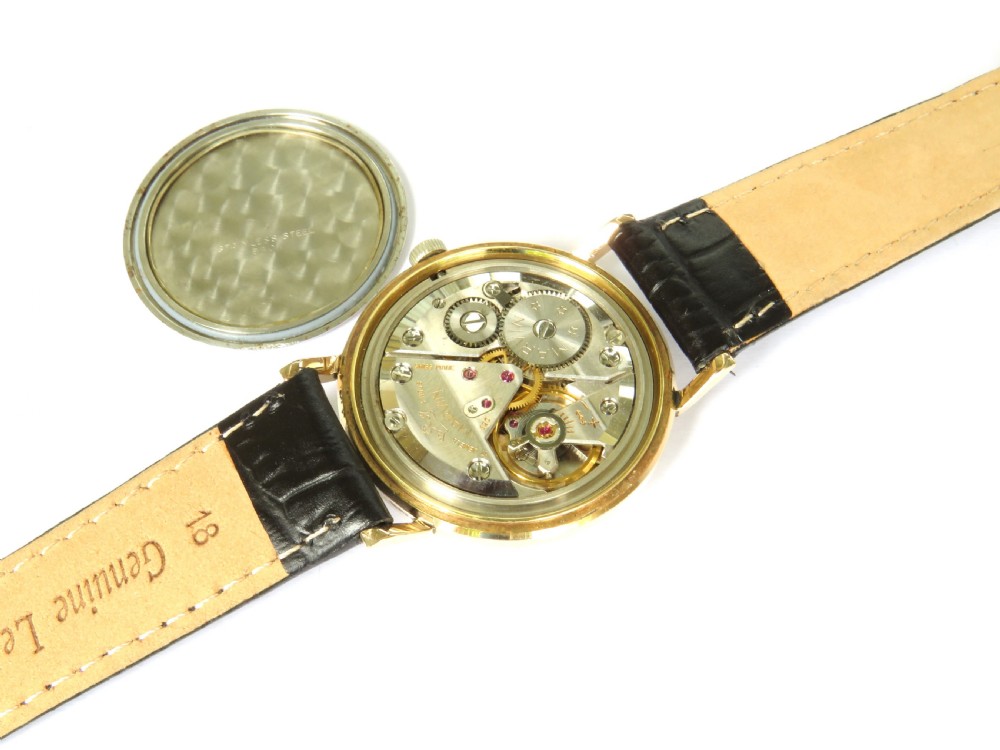 A 1960s vintage Marvin Hermetic gents wrist watch featuring a gold-toned circular case, champagne dial with applied baton hour markers, and a textured black leather strap. View III