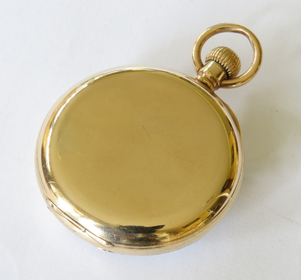 An open-face gold pocket watch featuring a white enamel dial, black Roman numerals, and a subsidiary seconds dial at six oclock. View V
