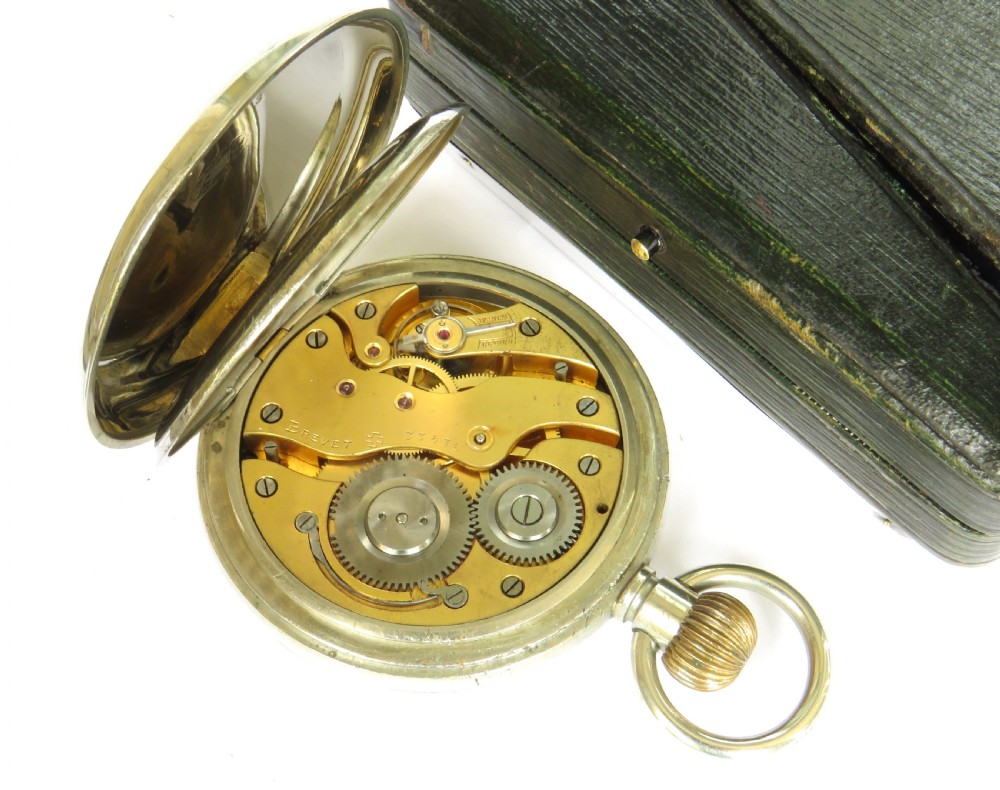 A rectangular silver travel desk clock featuring bow and garland engravings surrounding a white enamel dial with Roman numerals. View IV