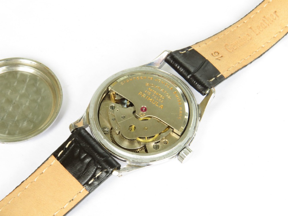 A 1950s gentlemens Primula Swiss automatic wristwatch featuring a silver-tone case, cream dial with gold-tone Arabic numerals, sub-seconds dial, and a black leather strap. View III