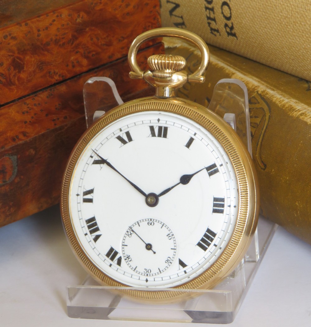 A 1920s open-face gold pocket watch featuring a white enamel dial with black Roman numerals and a subsidiary seconds dial.