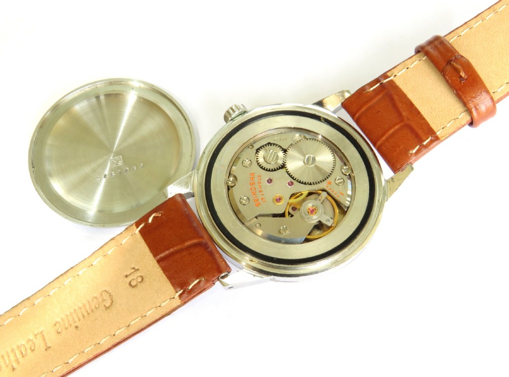 A 1960s gents Seiko Sportsman Diashock wristwatch featuring a silver case, champagne dial with baton indices, and a brown leather strap. View III