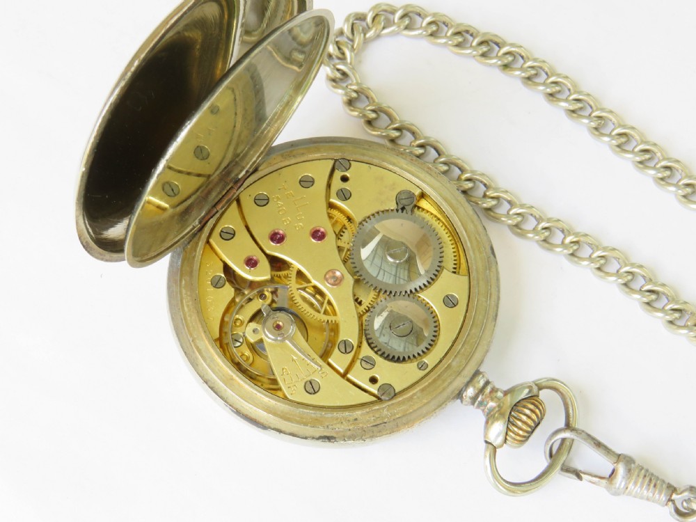 A 1930s Tellus open-face pocket watch featuring a white dial with black Arabic numerals and a silver-tone curb link chain with a T-bar. View IV