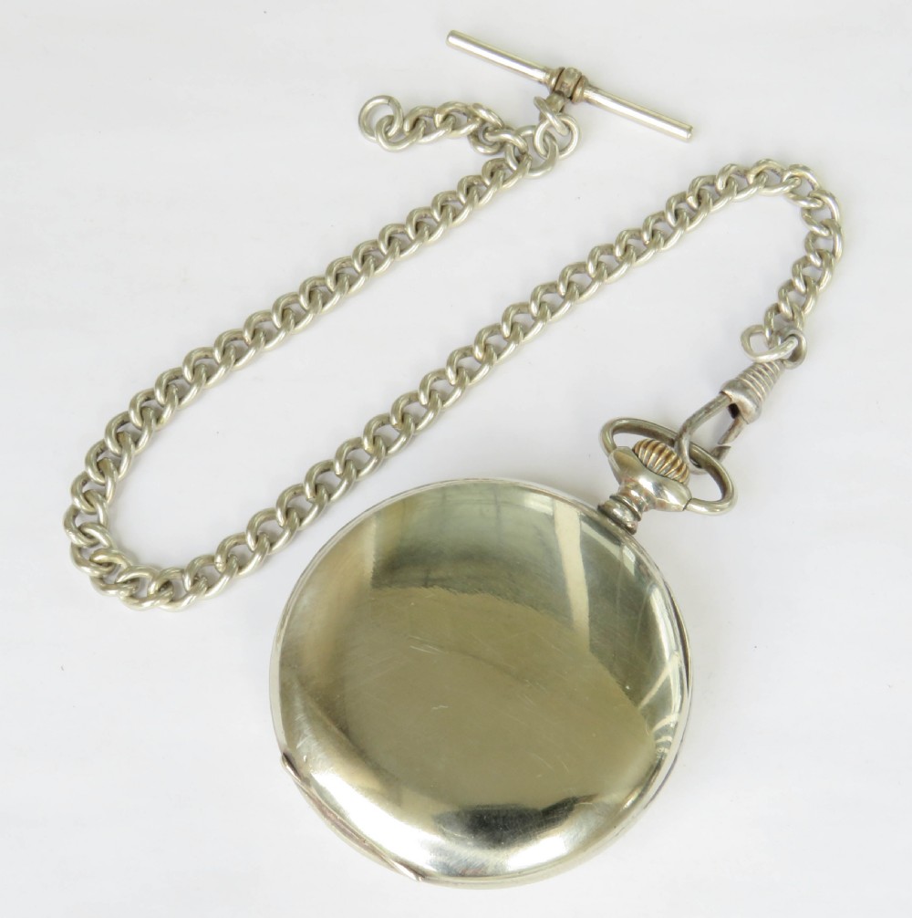 A 1930s Tellus open-face pocket watch featuring a white dial with black Arabic numerals and a silver-tone curb link chain with a T-bar. View V