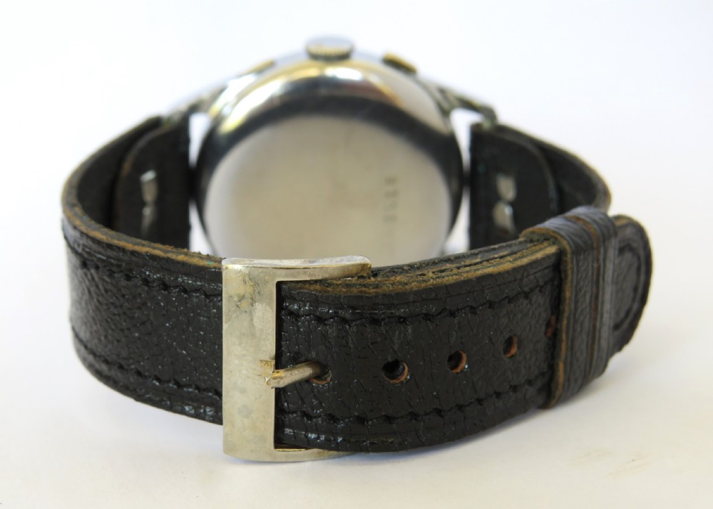 A 1940s gents chronograph wrist watch featuring an off-white dial with two vertical sub-dials, a metallic case, and a black leather strap. View V