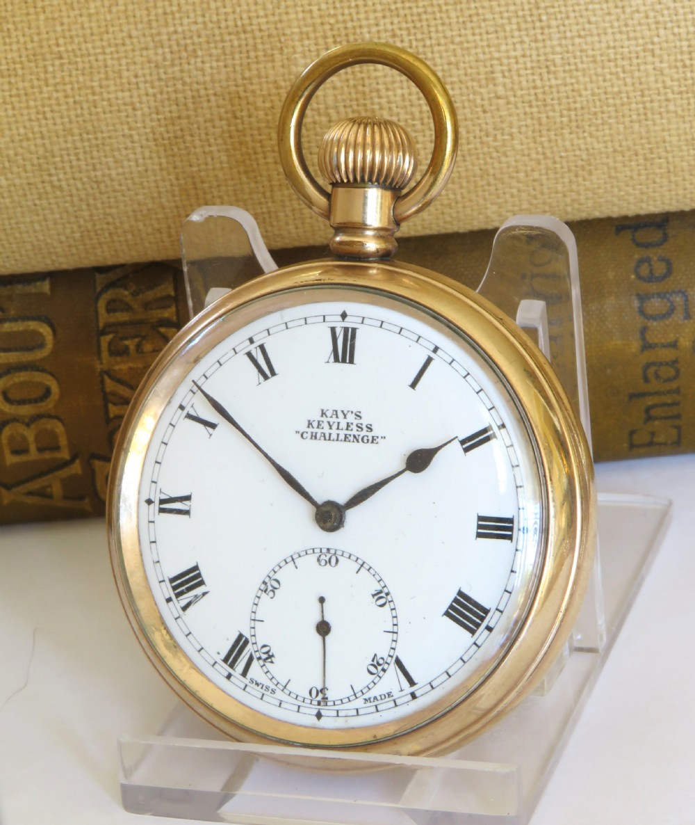 A gold-toned open-face pocket watch featuring a white enamel dial with black Roman numerals and a subsidiary seconds dial.