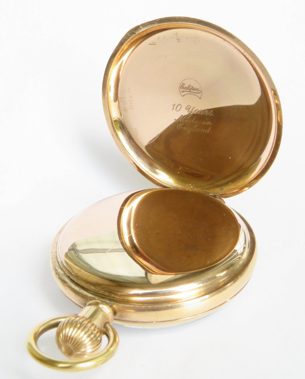 A gold-toned open-face pocket watch featuring a white enamel dial with black Roman numerals and a subsidiary seconds dial. View IV