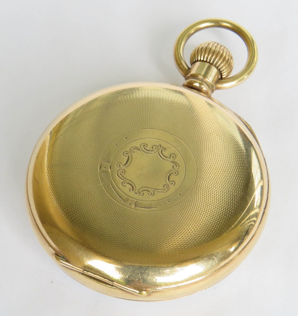 A gold-toned open-face pocket watch featuring a white enamel dial with black Roman numerals and a subsidiary seconds dial. View VI