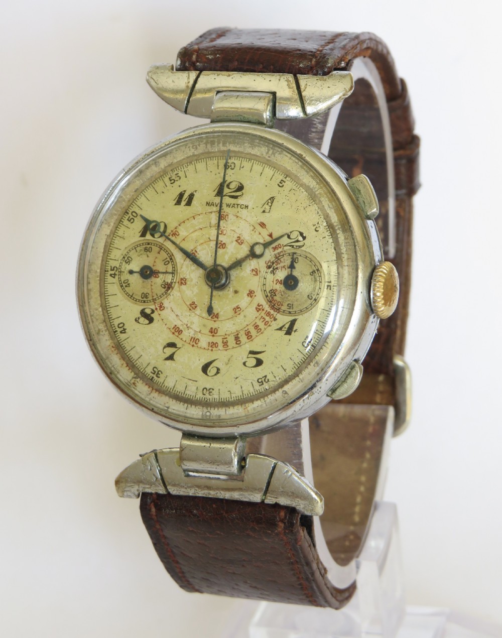 A 1930s gents chronograph wristwatch featuring a patinated cream dial, dual sub-dials, silver-tone case, and a textured brown leather strap.