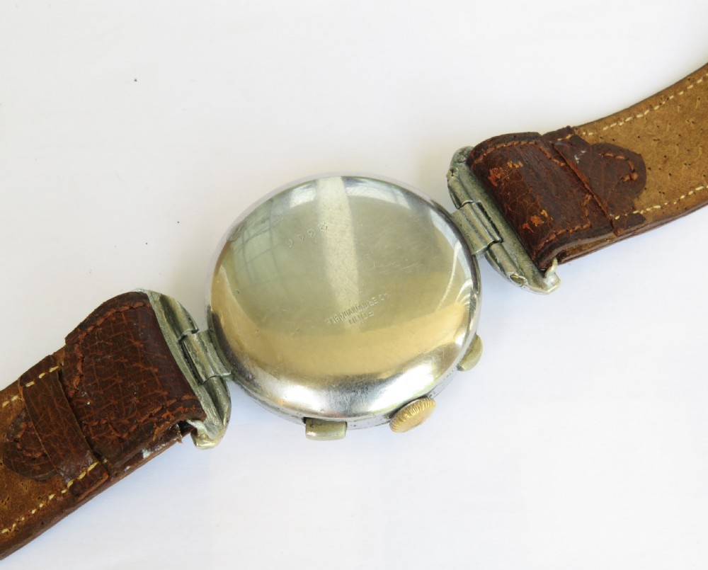 A 1930s gents chronograph wristwatch featuring a patinated cream dial, dual sub-dials, silver-tone case, and a textured brown leather strap. View IV