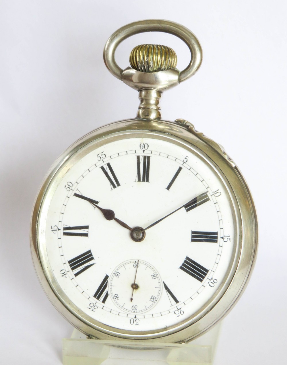 An antique open-face Goliath pocket watch with a white enamel dial, black Roman numerals, subsidiary seconds dial, and attached metal T-bar chain. View II