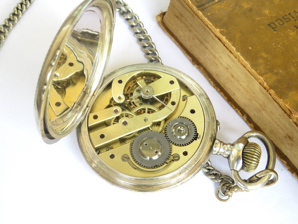 An antique open-face Goliath pocket watch with a white enamel dial, black Roman numerals, subsidiary seconds dial, and attached metal T-bar chain. View V