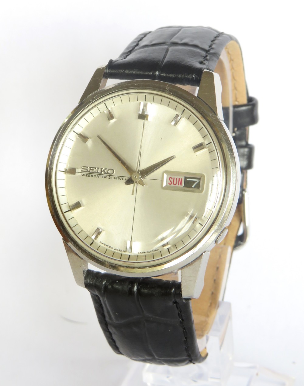 A vintage Seiko Sportsmatic Weekdater automatic wristwatch featuring a round silver dial with a day-date window and a black embossed leather strap.