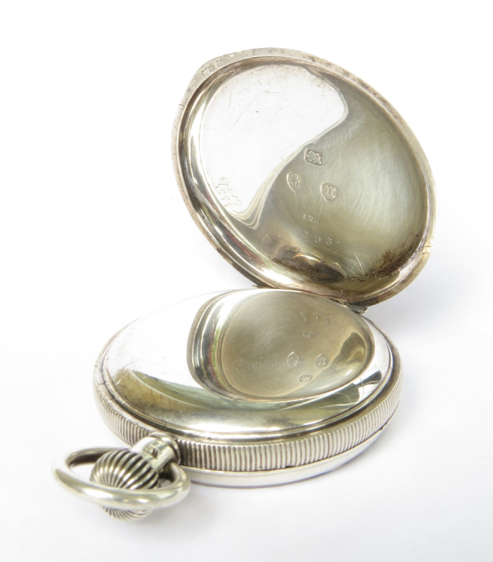 An open-face antique silver pocket watch featuring a white enamel dial with black Roman numerals and steel hands. View III