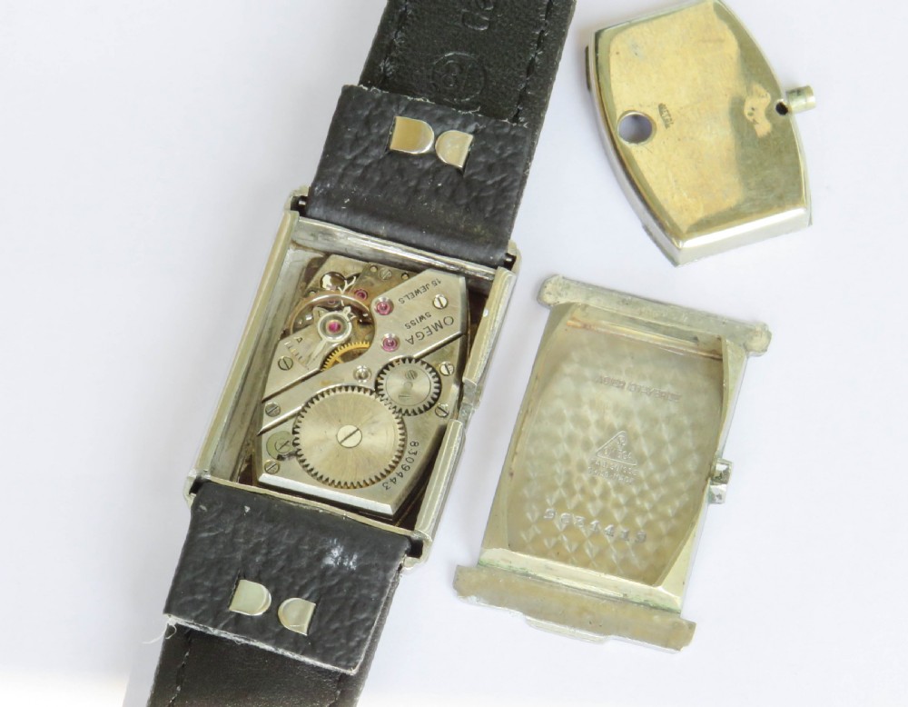 A 1930s rectangular Omega gents wristwatch featuring a silver-tone case, aged cream dial with Arabic numerals, sub-seconds dial, and a tan leather strap. View III