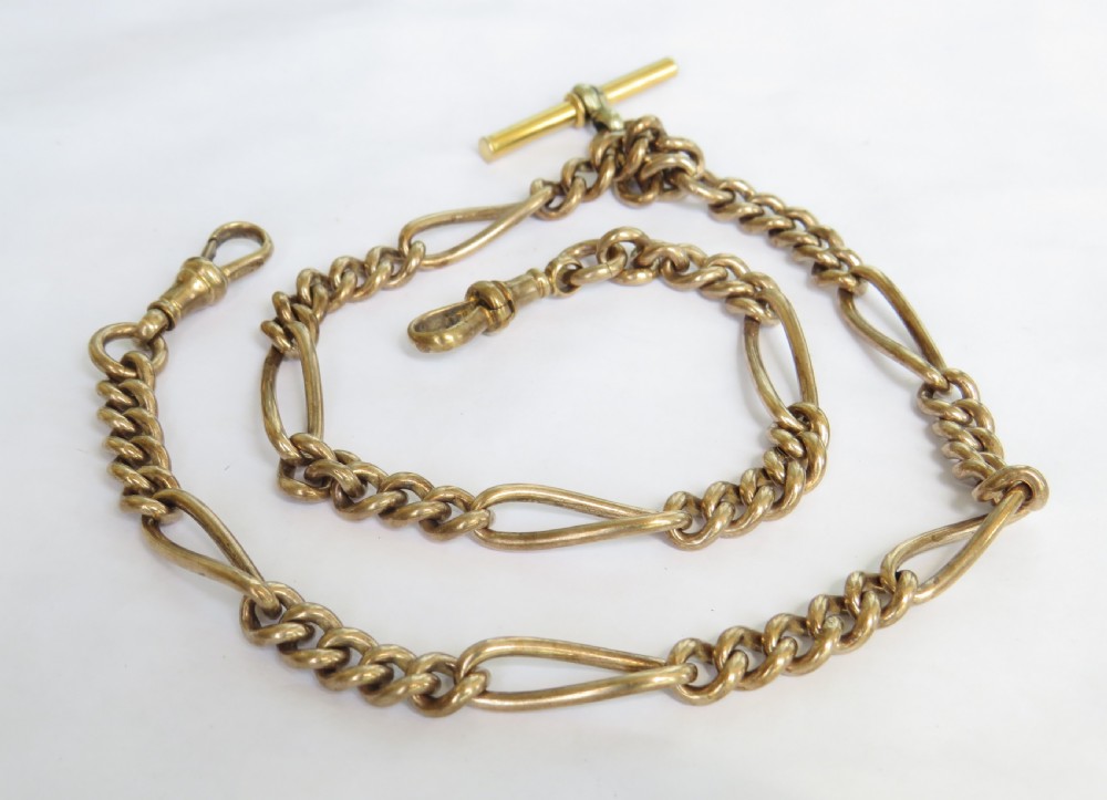 An antique rolled gold double Albert watch chain featuring elongated fetter links, curb chain sections, two swivel clasps, and a central T-bar.