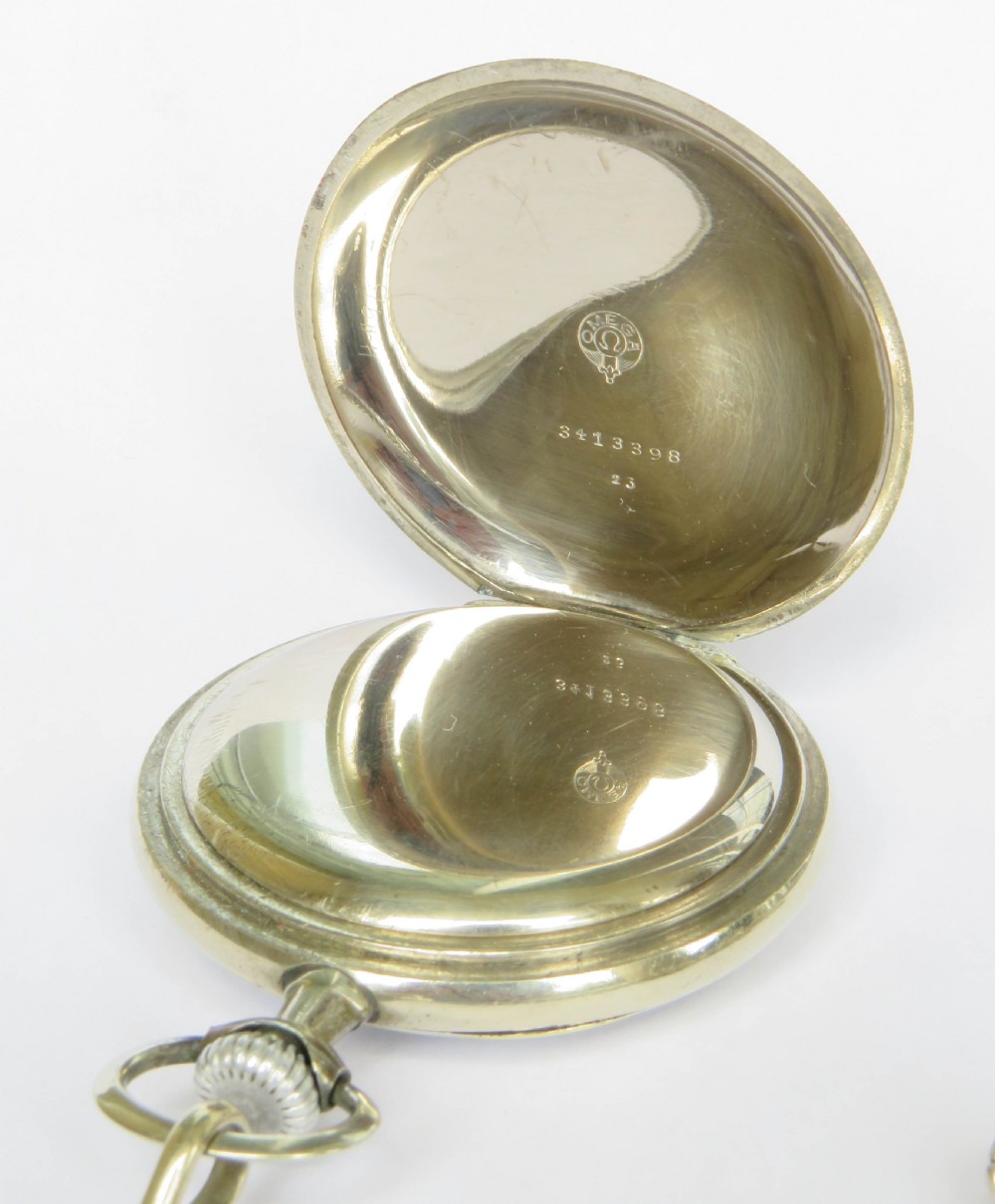 An open-face antique Omega pocket watch with a white enamel dial, black Arabic numerals, a sub-seconds dial, and an attached silver curb link chain with a T-bar and decorative shield fob. View IV