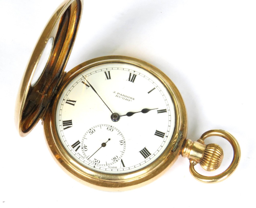 A 1930s gold-toned half hunter pocket watch displayed open, revealing a white dial with black Roman numerals and a subsidiary seconds dial. View II