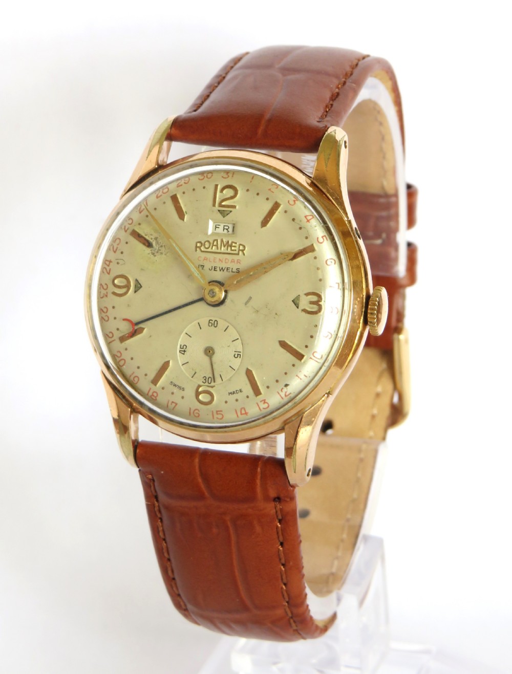 A 1950s gents Roamer Calendar wristwatch featuring a gold-plated case, champagne dial with pointer date function, sub-seconds dial, and a brown leather strap.