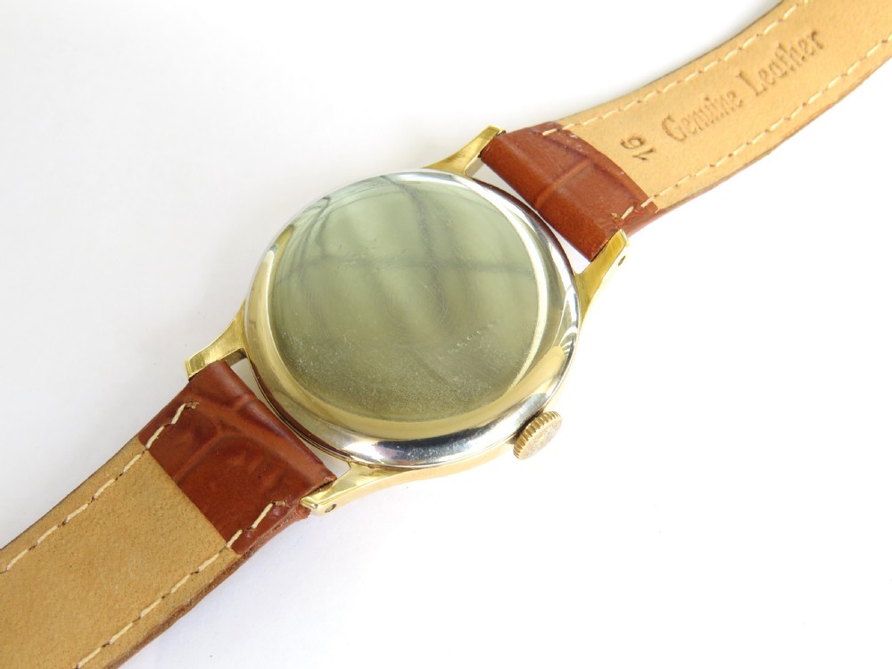 A 1950s gents J W Benson wristwatch with a gold-plated case, cream dial featuring Roman numerals and sub-seconds register, and a brown leather strap. View IV