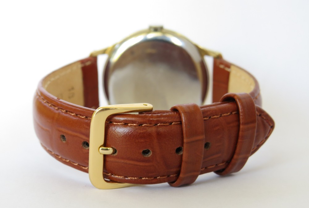 A gents gold-plated circular wristwatch with a cream dial, gold Arabic numerals, red-tipped second hand, and brown leather strap. View V