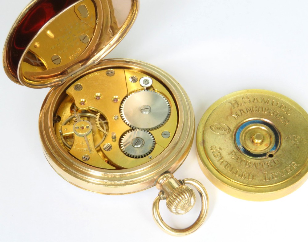 An open-face antique gold-toned pocket watch with a white enamel dial, black Roman numerals, and a subsidiary seconds display. View V