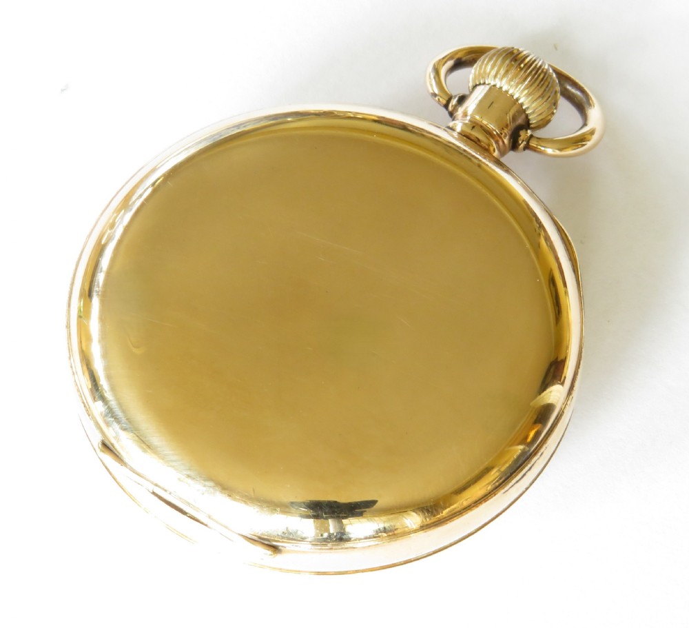 An open-face antique gold-toned pocket watch with a white enamel dial, black Roman numerals, and a subsidiary seconds display. View VI
