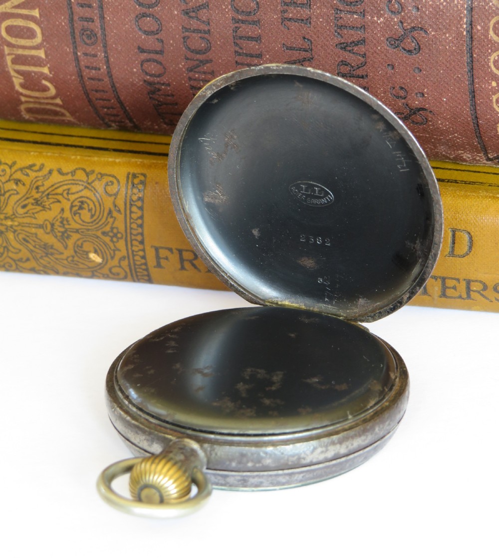 An open-face 1915 Waltham pocket watch featuring a white enamel dial with black Roman numerals, a sub-seconds dial, and a brass winding crown. View III
