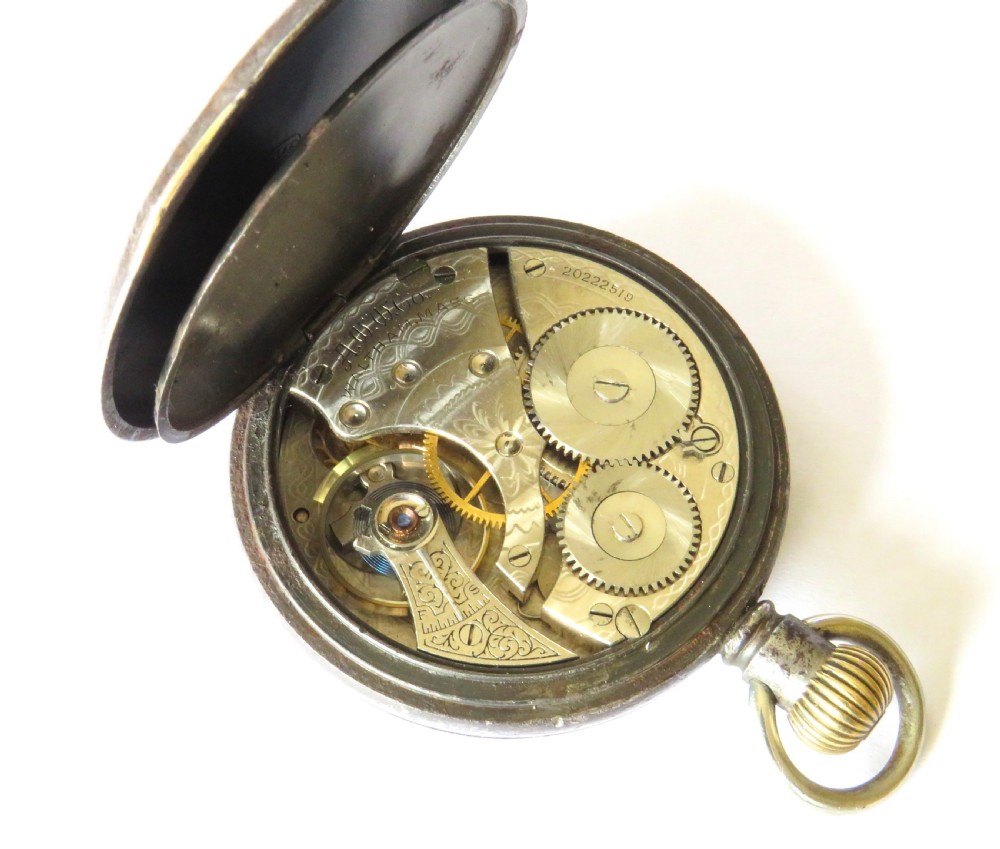 An open-face 1915 Waltham pocket watch featuring a white enamel dial with black Roman numerals, a sub-seconds dial, and a brass winding crown. View IV