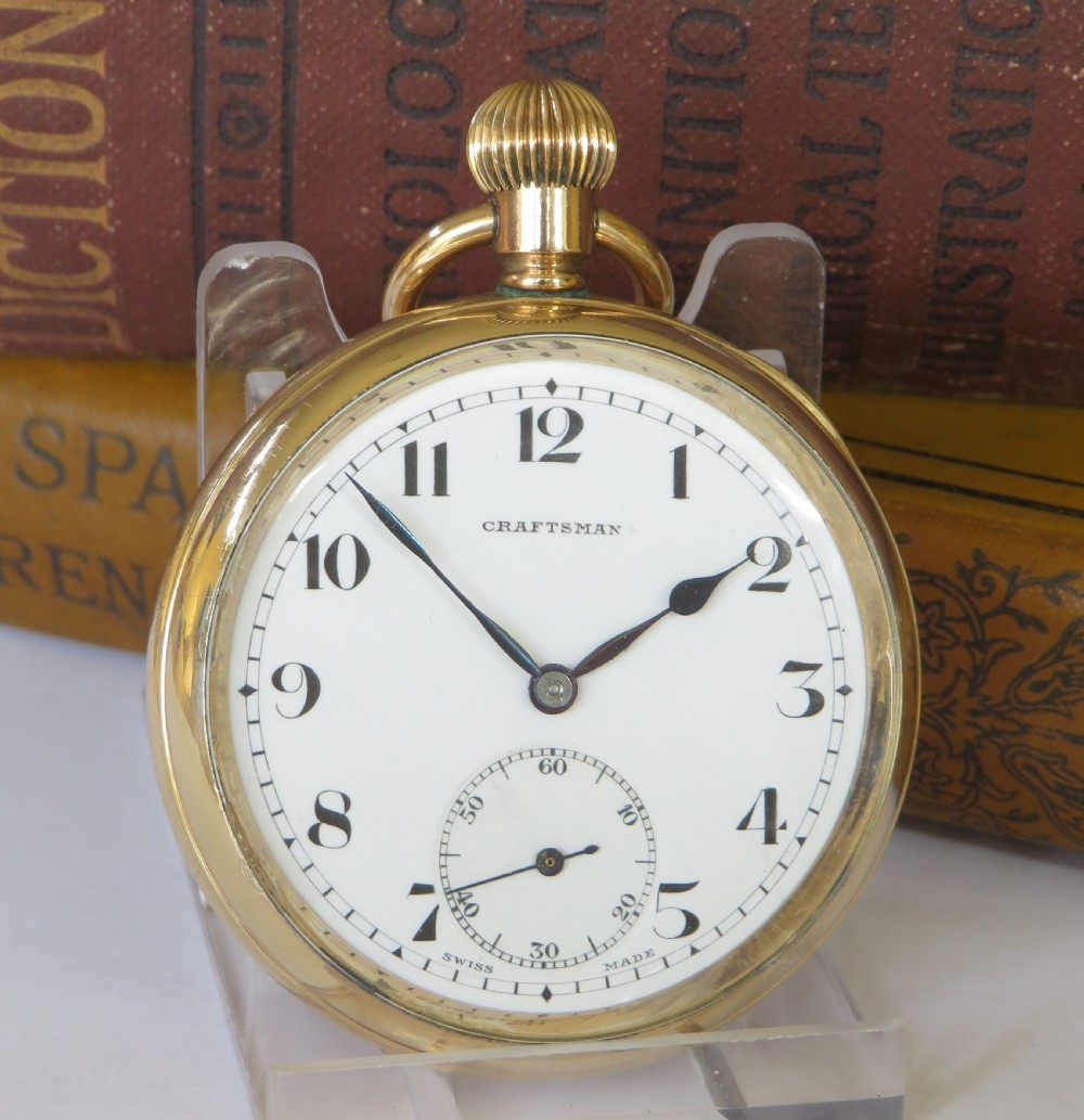 A 1930s gold-toned open-face pocket watch featuring a white dial, bold black Arabic numerals, and a small subsidiary seconds dial at the bottom. View II