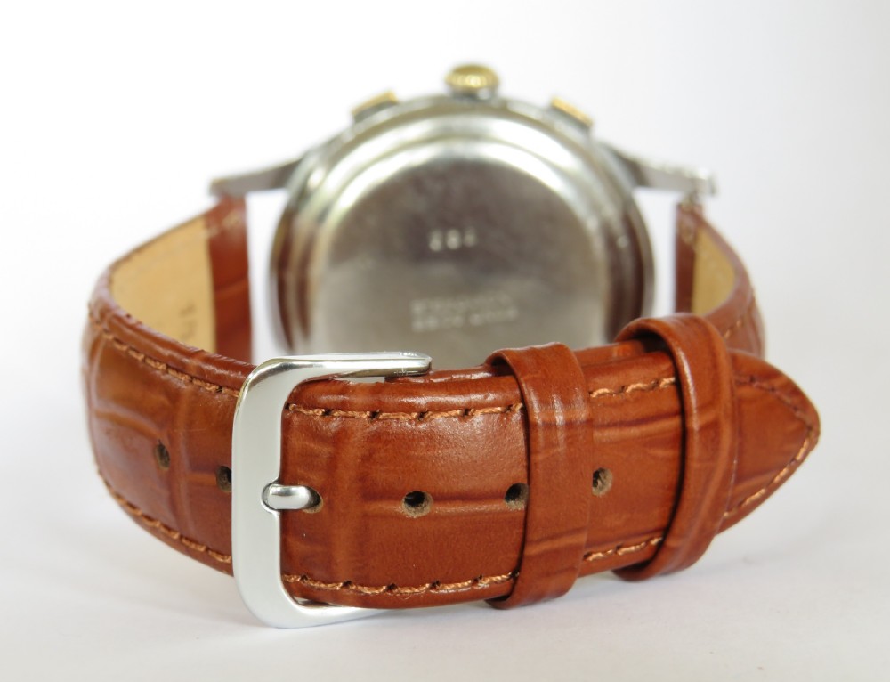 A 1950s vintage chronograph wristwatch featuring a cream dial with two sub-dials, a silver-tone metal case, and a brown leather strap. View V