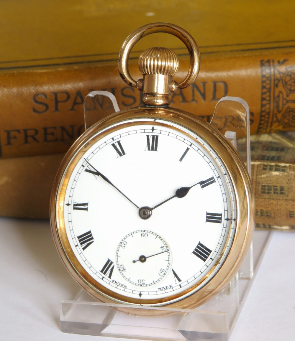 A 1920s Swiss open-face pocket watch featuring a gold-toned case, a white dial with black Roman numerals, and a subsidiary seconds dial at the six oclock position.
