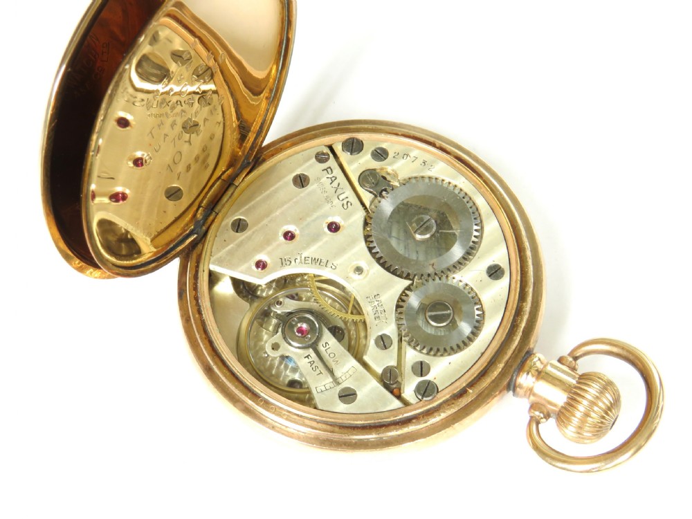 A 1920s Swiss open-face pocket watch featuring a gold-toned case, a white dial with black Roman numerals, and a subsidiary seconds dial at the six oclock position. View IV