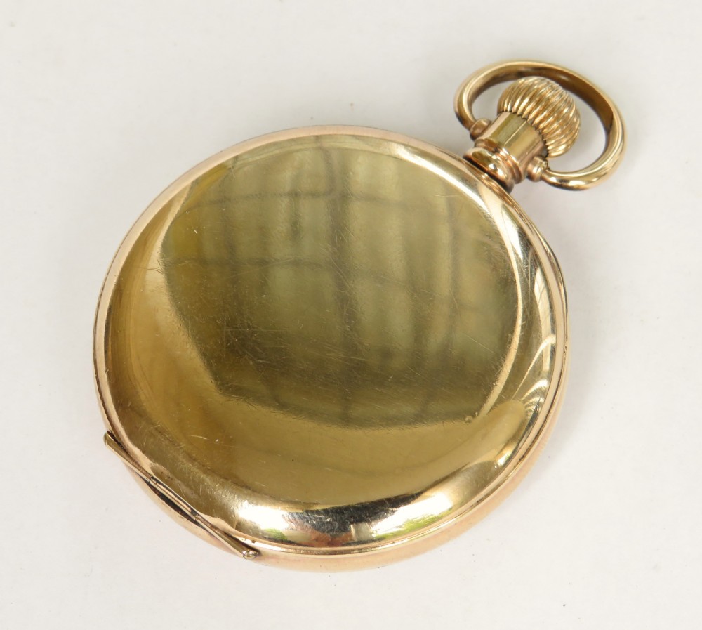 A 1920s Swiss open-face pocket watch featuring a gold-toned case, a white dial with black Roman numerals, and a subsidiary seconds dial at the six oclock position. View V