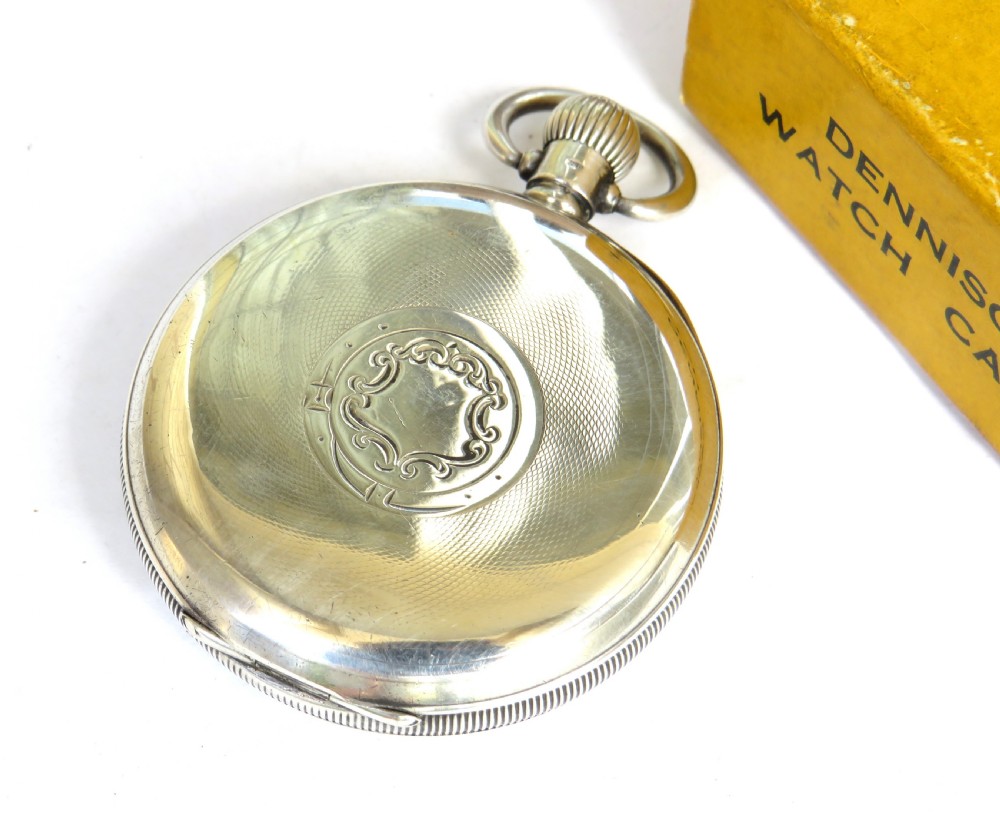 An antique 1922 open-face silver pocket watch featuring a white enamel dial with Roman numerals alongside its original yellow Dennison box. View IV