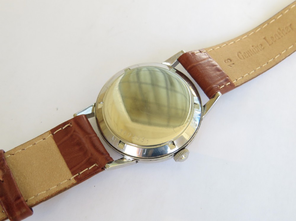 A 1950s Eterna-Matic gents wrist watch featuring a champagne dial, gold-tone hour markers, date aperture, and a brown leather strap. View III