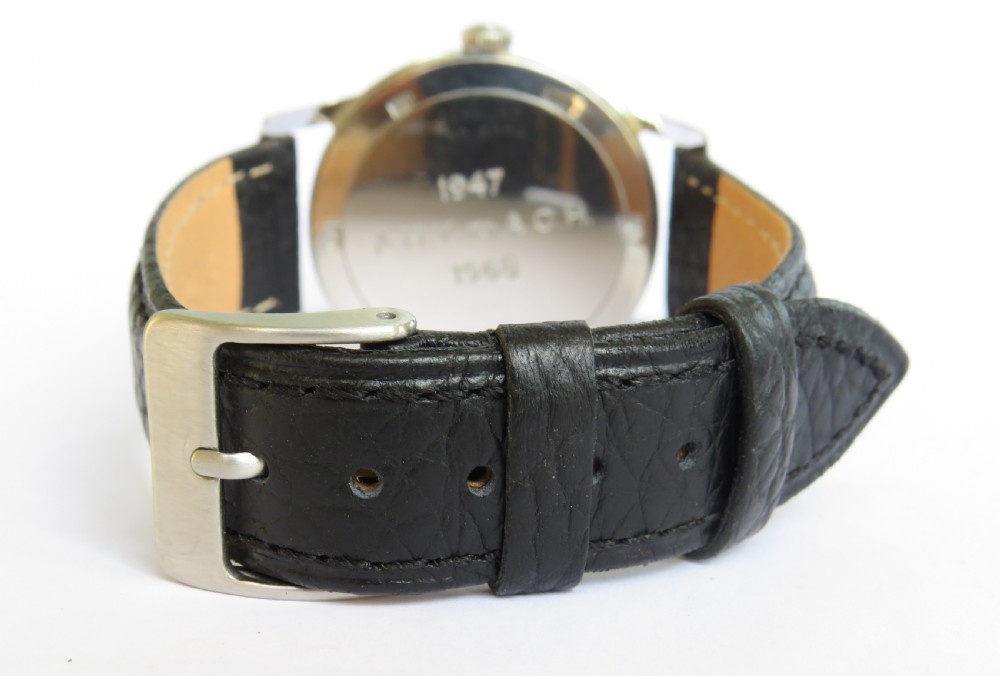 A 1968 Certina Waterking gents wristwatch featuring a silver-tone case, cream dial with Arabic quarter numerals, crosshair sub-seconds dial, and black textured leather strap. View V