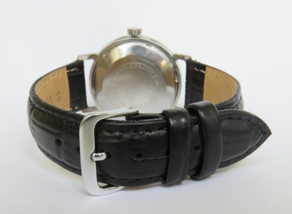 A 1960s gents Gruen Precision Auto-Wind wrist watch with a silver dial, day-date window, and black leather strap. View V