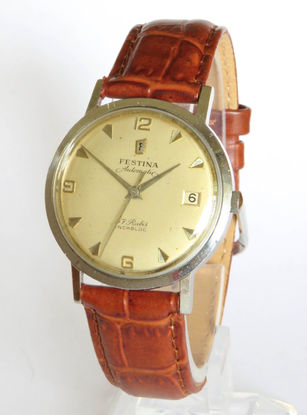 A gents 1950s Festina automatic wristwatch featuring a champagne dial, silver-tone case, and brown leather strap.