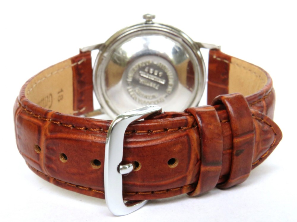 A gents 1950s Festina automatic wristwatch featuring a champagne dial, silver-tone case, and brown leather strap. View V