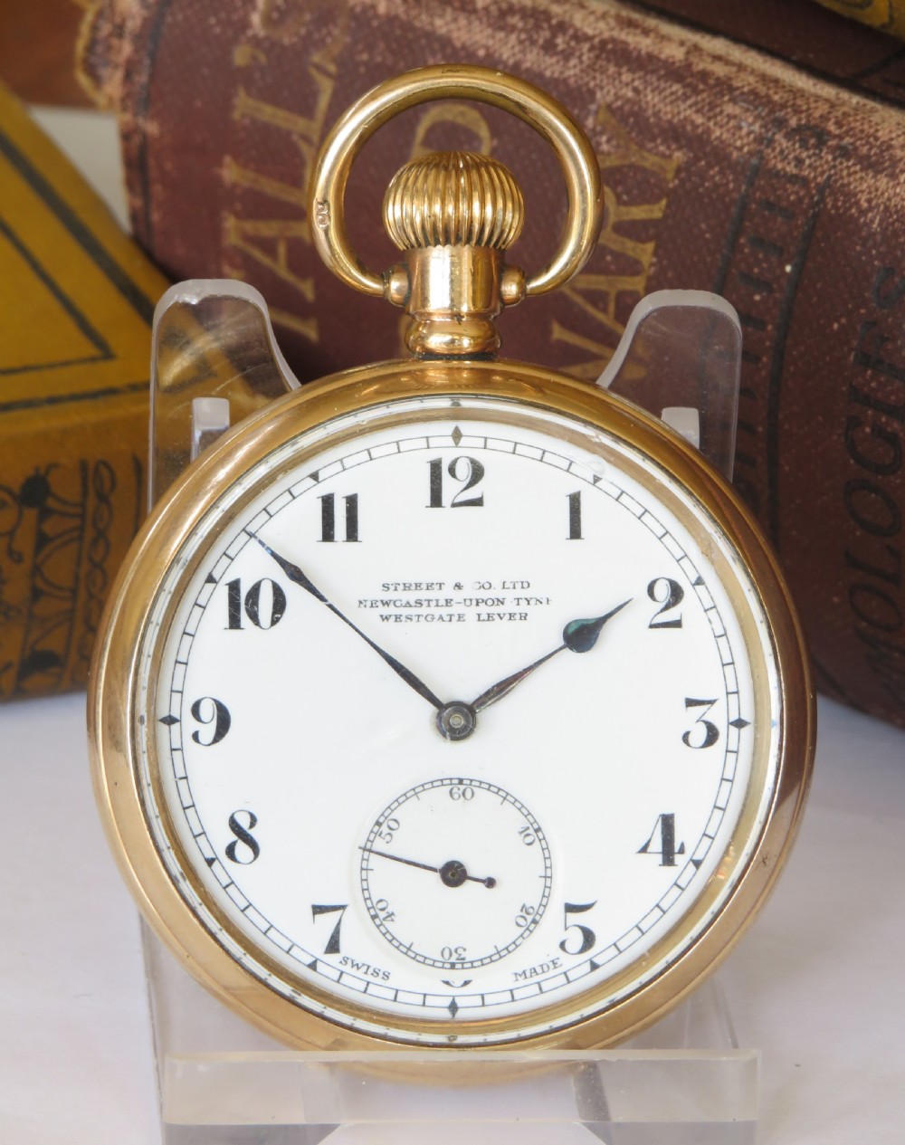 An open face stem winding gold pocket watch featuring a white enamel dial with black Arabic numerals and a subsidiary seconds subdial. View II