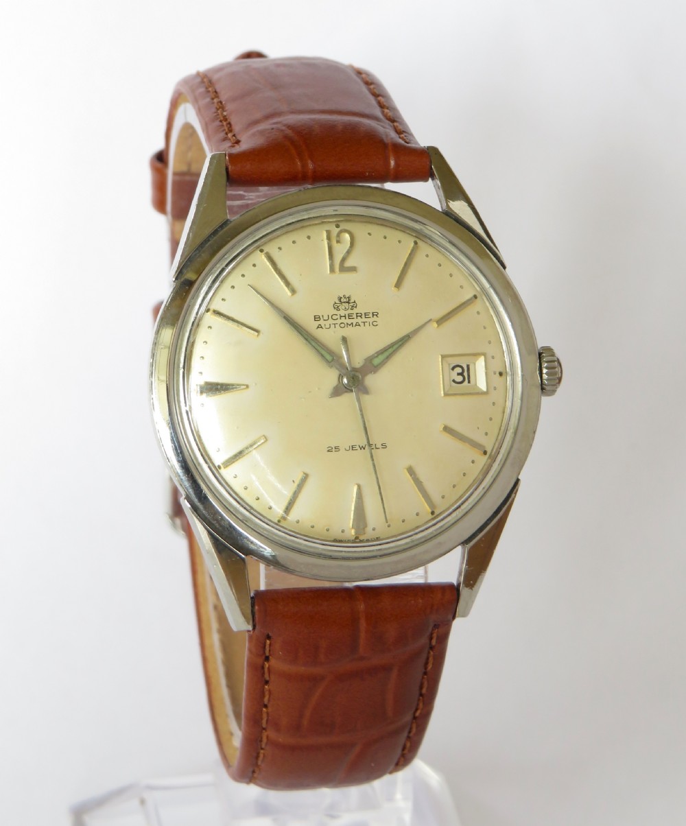 A vintage gentlemens Bucherer automatic wrist watch featuring a champagne dial with baton indices, date window, silver-toned metal case, and textured brown leather strap. View II