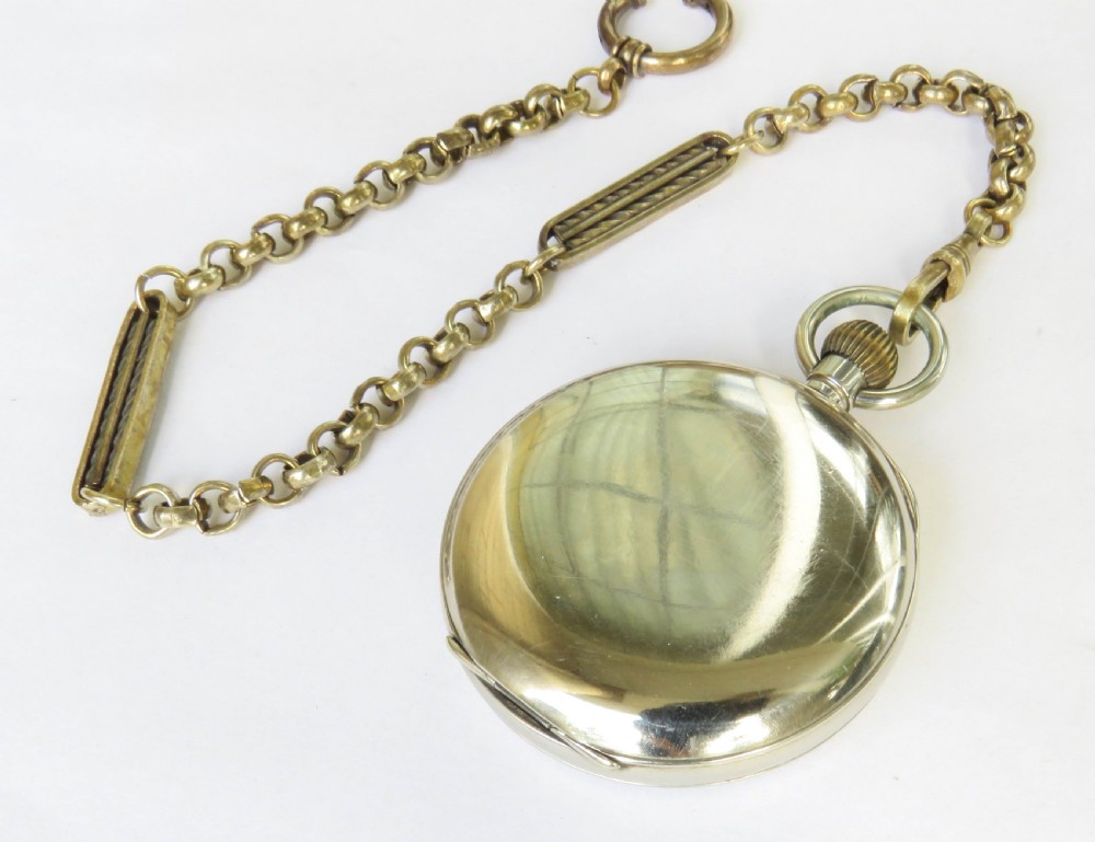 An antique silver-tone Octava 8-day open-face pocket watch featuring a white enamel dial with black Arabic numerals and an attached chain. View VI