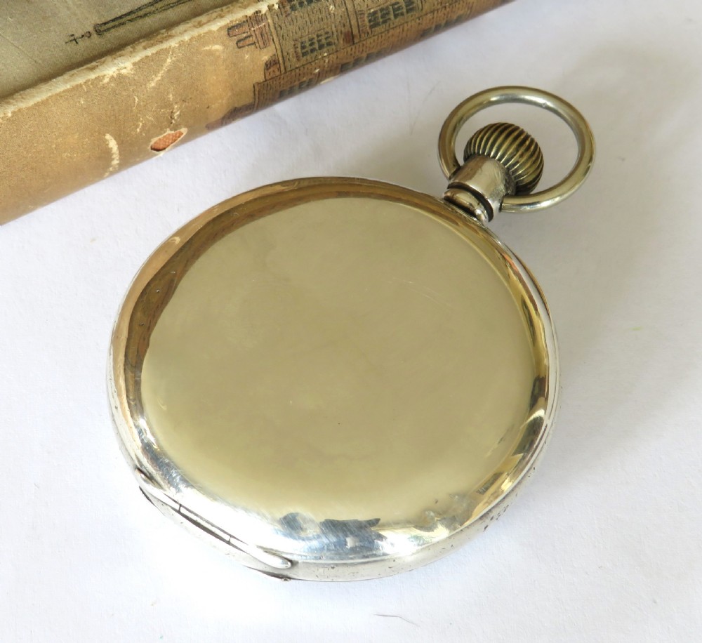 A silver open-face pocket watch with a white enamel dial, black Arabic numerals, and a small subsidiary seconds subdial at six oclock. View V