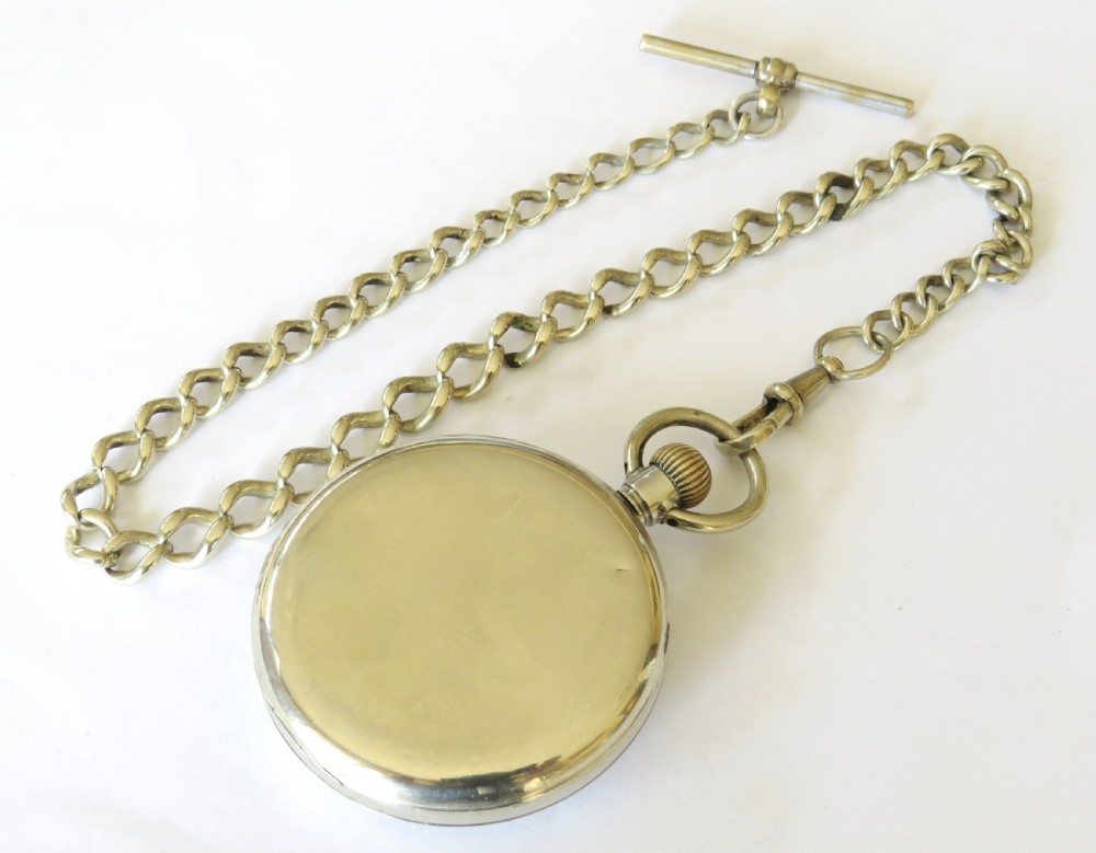 A 1920s Cyma open-face pocket watch featuring a white enamel dial with black Arabic numerals, a sub-seconds dial, and an attached link chain with a T-bar. View IV