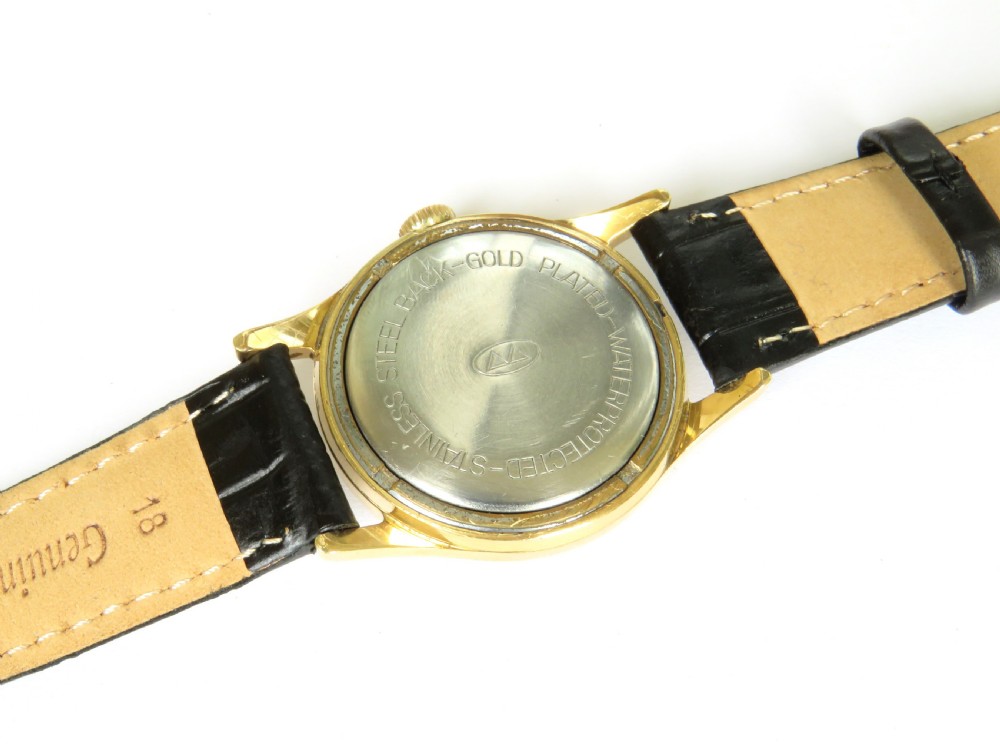A 1950s gents Berg Parat wristwatch featuring a gold-plated case, a black dial with gold numerals, and a black leather strap. View III