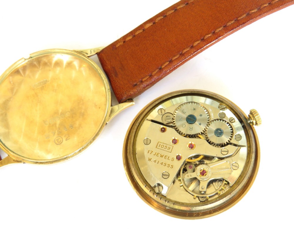 A 1960s gents 9ct gold Rone Seventeen wristwatch featuring a champagne dial with gold Arabic numerals and a brown leather strap. View V