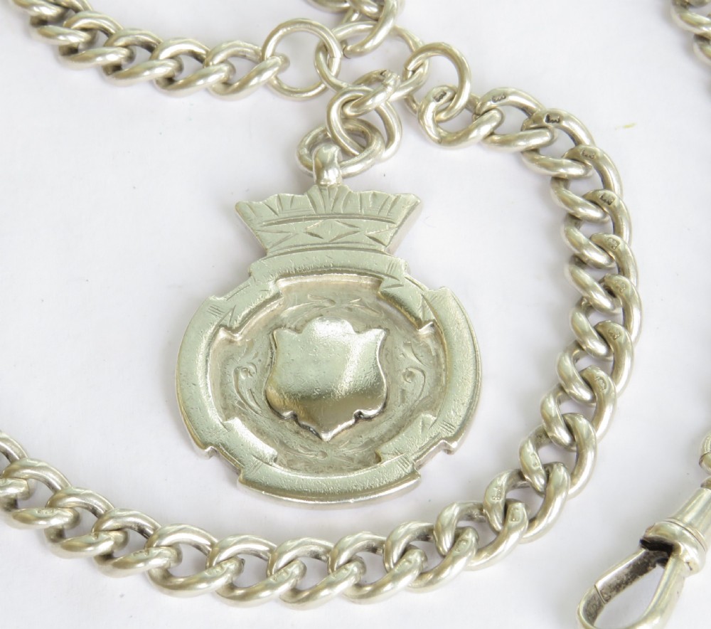 An antique sterling silver double Albert pocket watch chain featuring curb links, two swivel clasps, a central T-bar, and an engraved shield fob medallion topped with a crown motif. View II