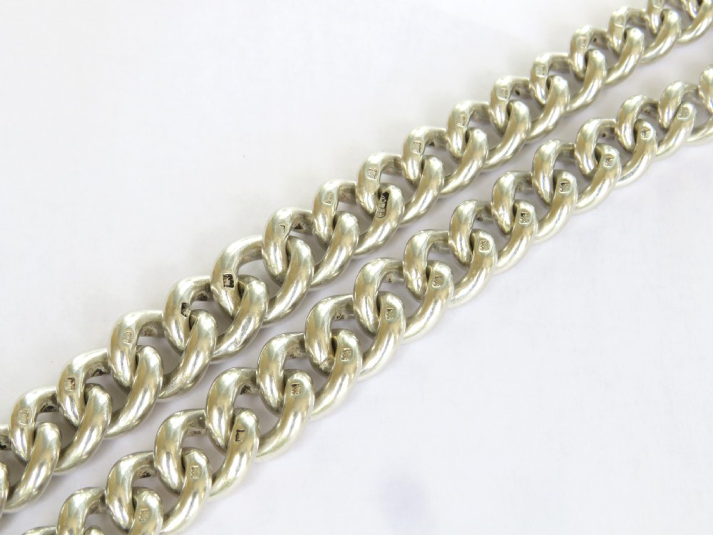 An antique silver double Albert pocket watch chain featuring curb links, two swivel dog clips, a central T-bar, and a decorative shield-shaped pendant fob. View IV