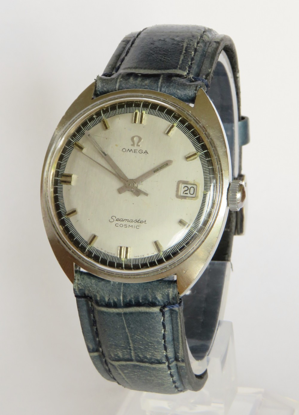 A 1960s gents Omega Seamaster Cosmic wristwatch featuring a stainless steel cushion case, silver dial with date display, and a blue leather strap.